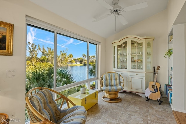 sunroom featuring lofted ceiling, ceiling fan, and a water view