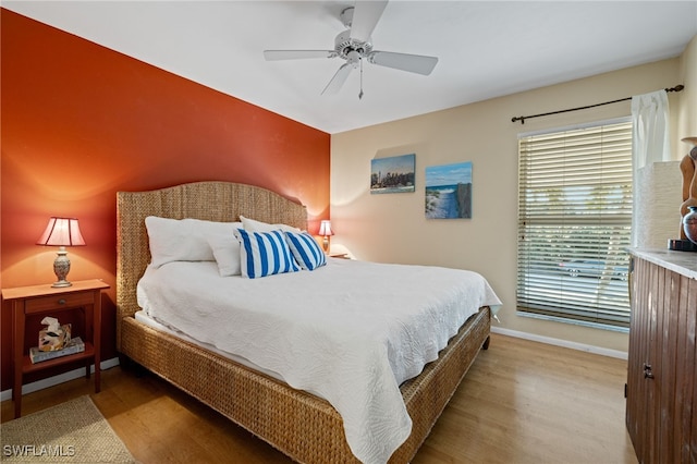 bedroom featuring ceiling fan, baseboards, and wood finished floors