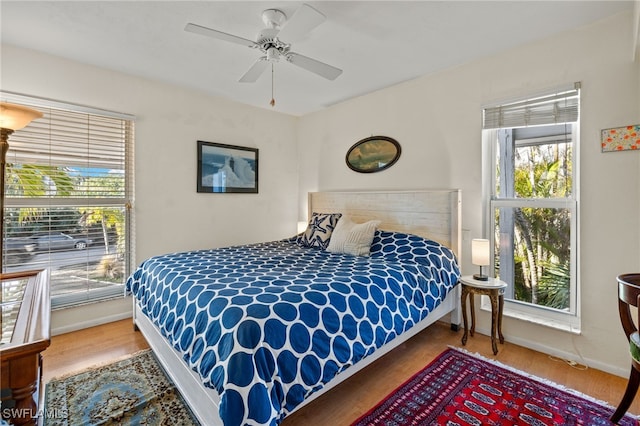 bedroom featuring ceiling fan, baseboards, and wood finished floors