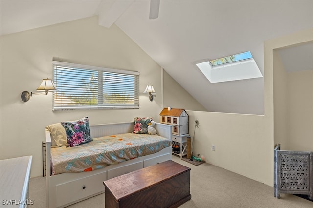 bedroom featuring carpet floors, vaulted ceiling with skylight, and a ceiling fan