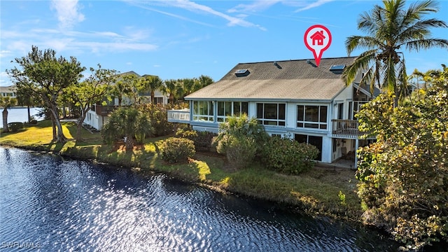 rear view of property with a water view and a sunroom