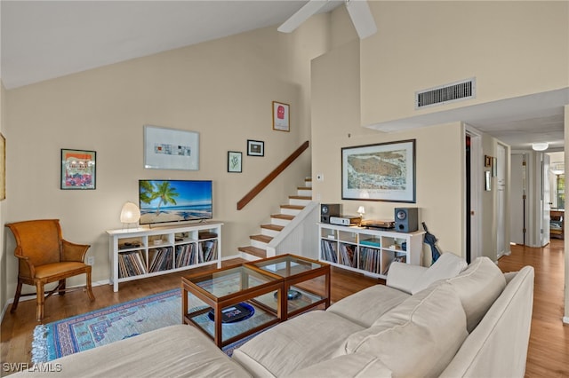 living area with stairway, baseboards, visible vents, and wood finished floors