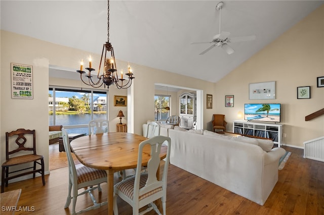 dining space featuring high vaulted ceiling, wood finished floors, and ceiling fan with notable chandelier