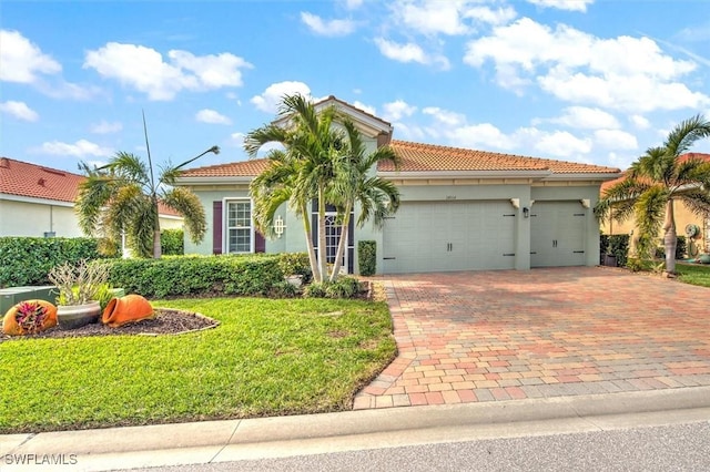 mediterranean / spanish-style home with a garage and a front lawn