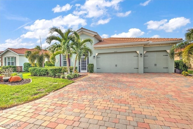 mediterranean / spanish home with a garage and a front yard