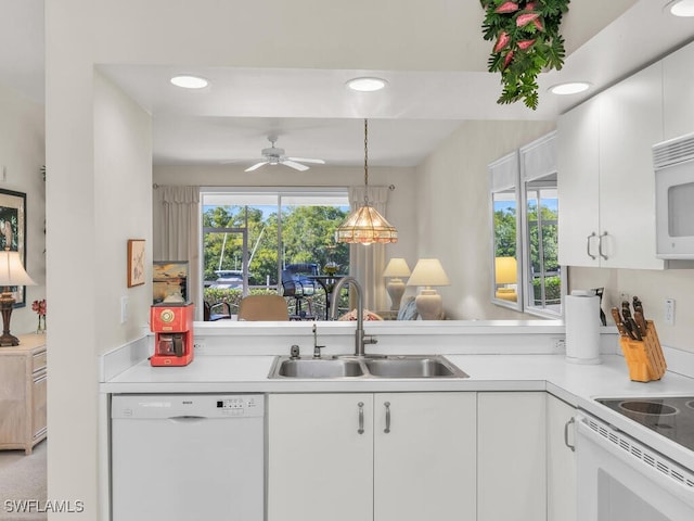 kitchen featuring sink, white appliances, a wealth of natural light, and white cabinets