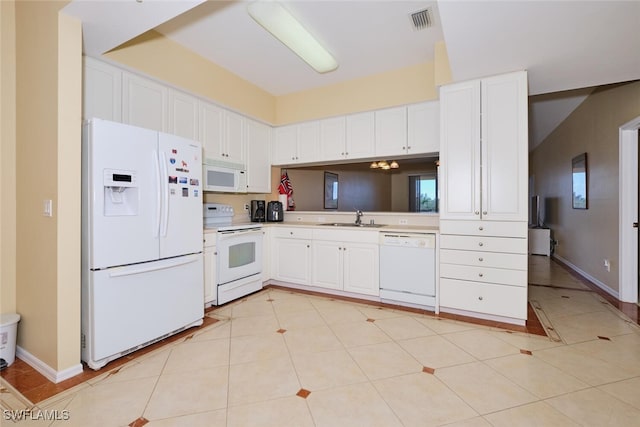 kitchen featuring white appliances, light tile patterned floors, sink, and white cabinets