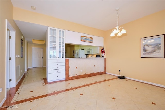 unfurnished dining area featuring tile patterned flooring and an inviting chandelier