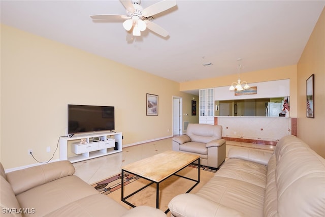 living room featuring tile patterned flooring and ceiling fan with notable chandelier