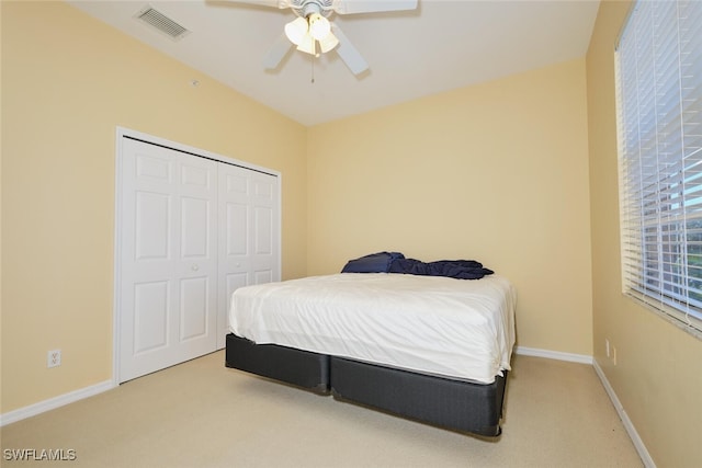 carpeted bedroom featuring ceiling fan and a closet