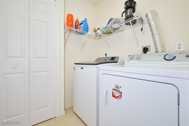 laundry room with light tile patterned flooring and washer and clothes dryer