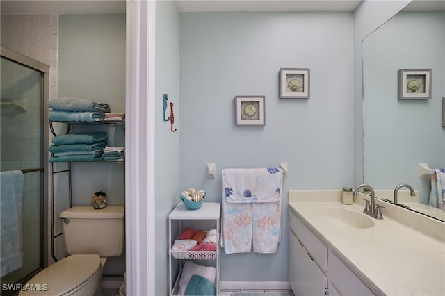 bathroom with an enclosed shower, vanity, and toilet