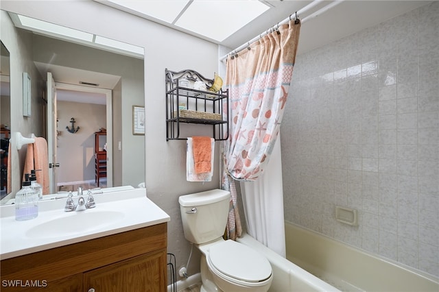 full bathroom with vanity, a skylight, shower / bath combination with curtain, and toilet