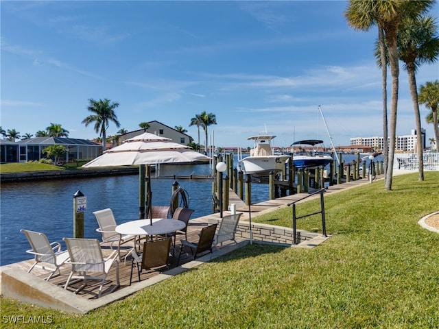 dock area with a yard and a water view