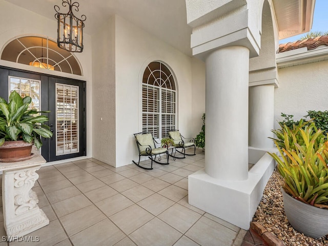 entrance to property featuring a porch and french doors