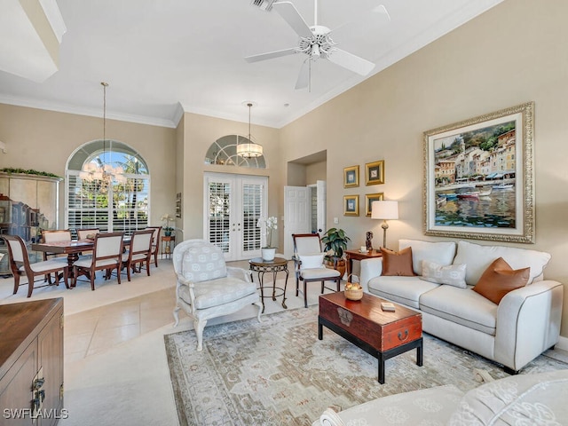 tiled living room featuring french doors, ornamental molding, ceiling fan with notable chandelier, and a high ceiling