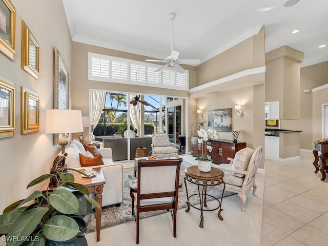 living room with ceiling fan, ornamental molding, light tile patterned floors, and a towering ceiling