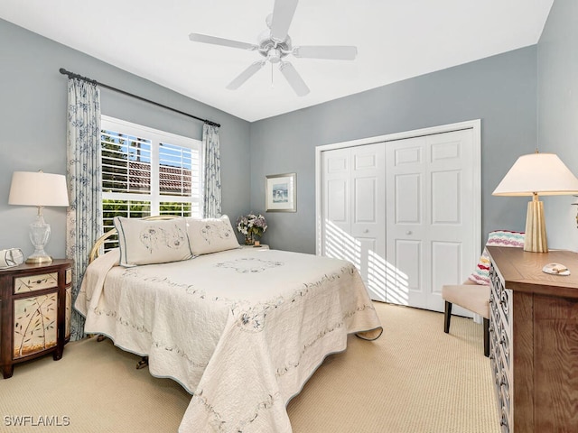 carpeted bedroom with ceiling fan and a closet