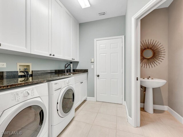 laundry area with cabinets, sink, washer and dryer, and light tile patterned floors