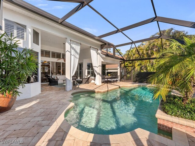 view of swimming pool featuring a lanai and a patio area