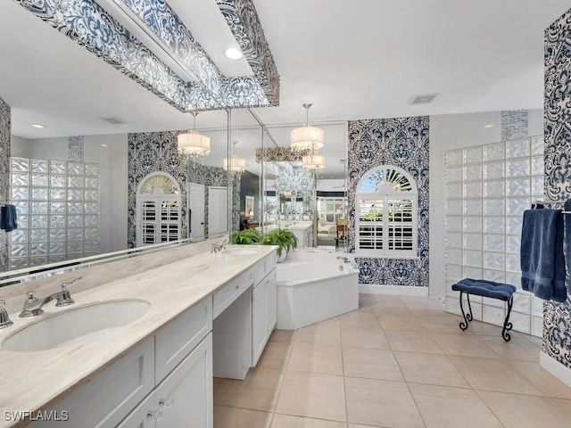 bathroom featuring tile patterned flooring, vanity, a tub, and tile walls