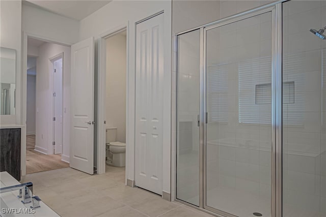 bathroom with an enclosed shower and toilet