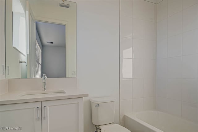 full bathroom featuring tiled shower / bath, vanity, and toilet