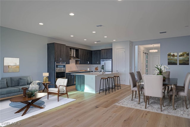 dining space with sink and light hardwood / wood-style floors