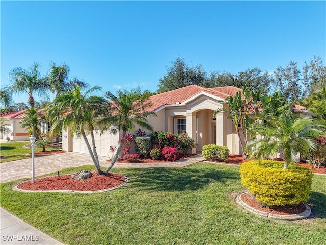 mediterranean / spanish home with a garage and a front yard