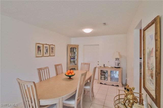 tiled dining area featuring a textured ceiling