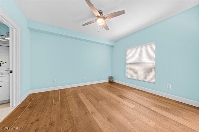 unfurnished bedroom featuring connected bathroom, ceiling fan, and light wood-type flooring