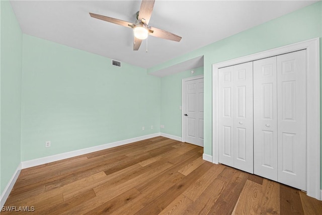 unfurnished bedroom featuring light wood-type flooring, ceiling fan, and a closet