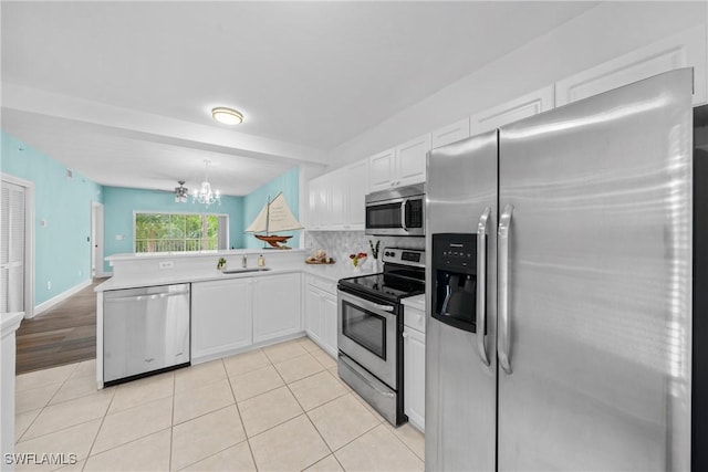 kitchen featuring pendant lighting, white cabinetry, backsplash, stainless steel appliances, and kitchen peninsula