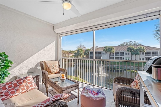 sunroom / solarium featuring a water view and ceiling fan