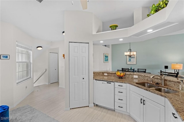 kitchen featuring stone countertops, pendant lighting, sink, white cabinets, and white dishwasher