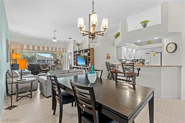 tiled dining space featuring ceiling fan with notable chandelier