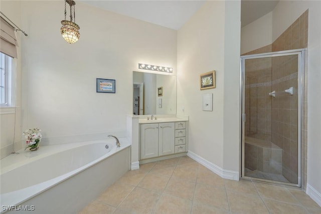 bathroom with a stall shower, baseboards, a garden tub, tile patterned flooring, and vanity