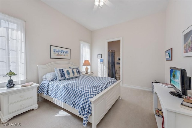 bedroom featuring baseboards, light colored carpet, ceiling fan, a walk in closet, and a closet