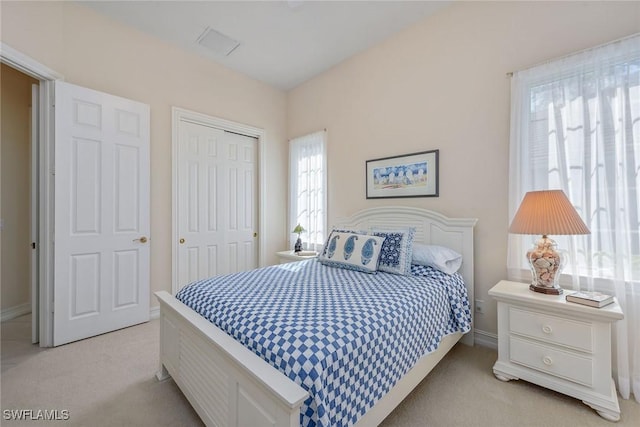 bedroom featuring a closet and light colored carpet