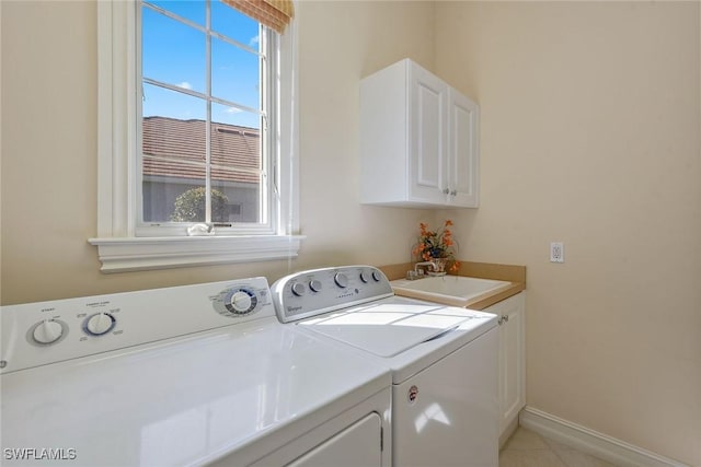 laundry area featuring cabinet space, baseboards, washer and dryer, and a sink