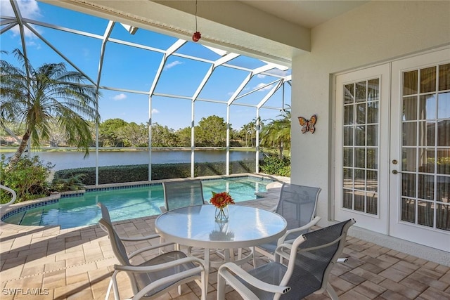 outdoor pool with a lanai, a water view, a patio, and french doors