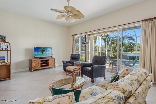 living room featuring ceiling fan, baseboards, and light tile patterned floors