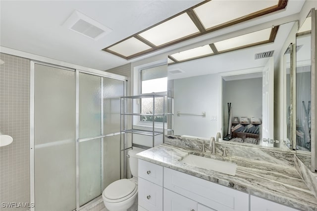 bathroom with ensuite bathroom, vanity, a shower stall, and visible vents