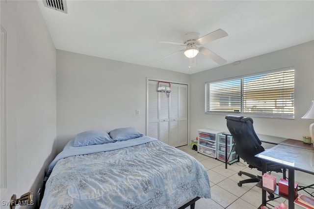 bedroom with light tile patterned floors, ceiling fan, a closet, and visible vents