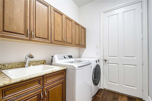 washroom with cabinets, sink, washing machine and clothes dryer, and dark hardwood / wood-style flooring