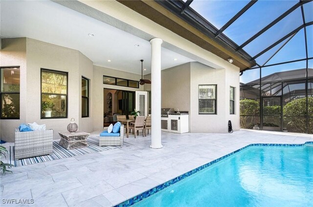 back of property with ceiling fan, an outdoor kitchen, an outdoor hangout area, and a patio area