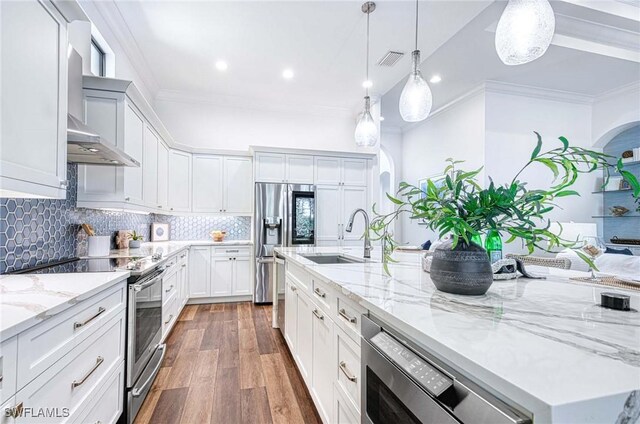 kitchen featuring light stone countertops, stainless steel appliances, hanging light fixtures, and white cabinets