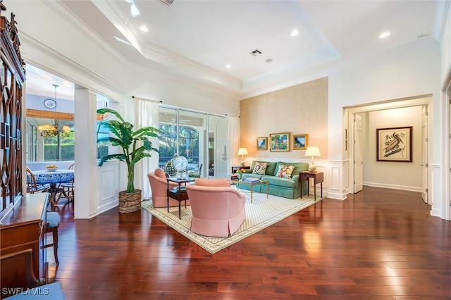 living room featuring a raised ceiling, visible vents, ornamental molding, and wood-type flooring