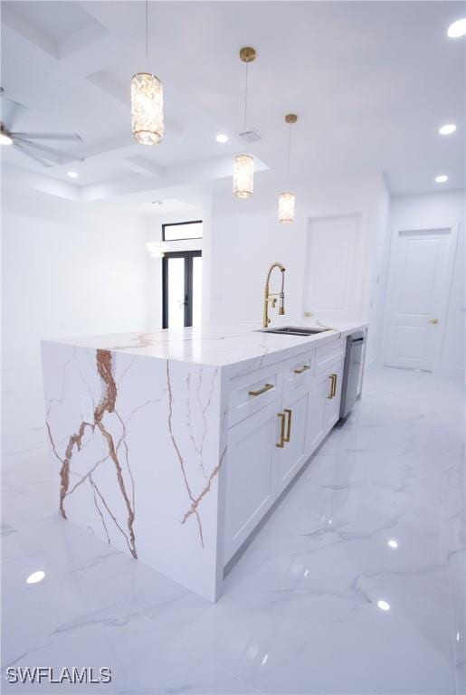 kitchen with decorative light fixtures, dishwasher, white cabinetry, sink, and light stone countertops