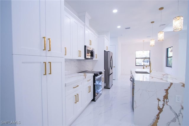 kitchen featuring white cabinetry, stainless steel appliances, sink, and light stone counters